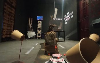 Suasana ruang pamer SISA di Rumah Tiara Coffee, Palu. Instalasi heterogen berupa benda-benda sisa, tali, tanah, dan wadah kosong disusun di ruang gelap, menciptakan lanskap simbolik tentang hubungan manusia, lingkungan, dan ruang hidup yang terus mengalami pergeseran.