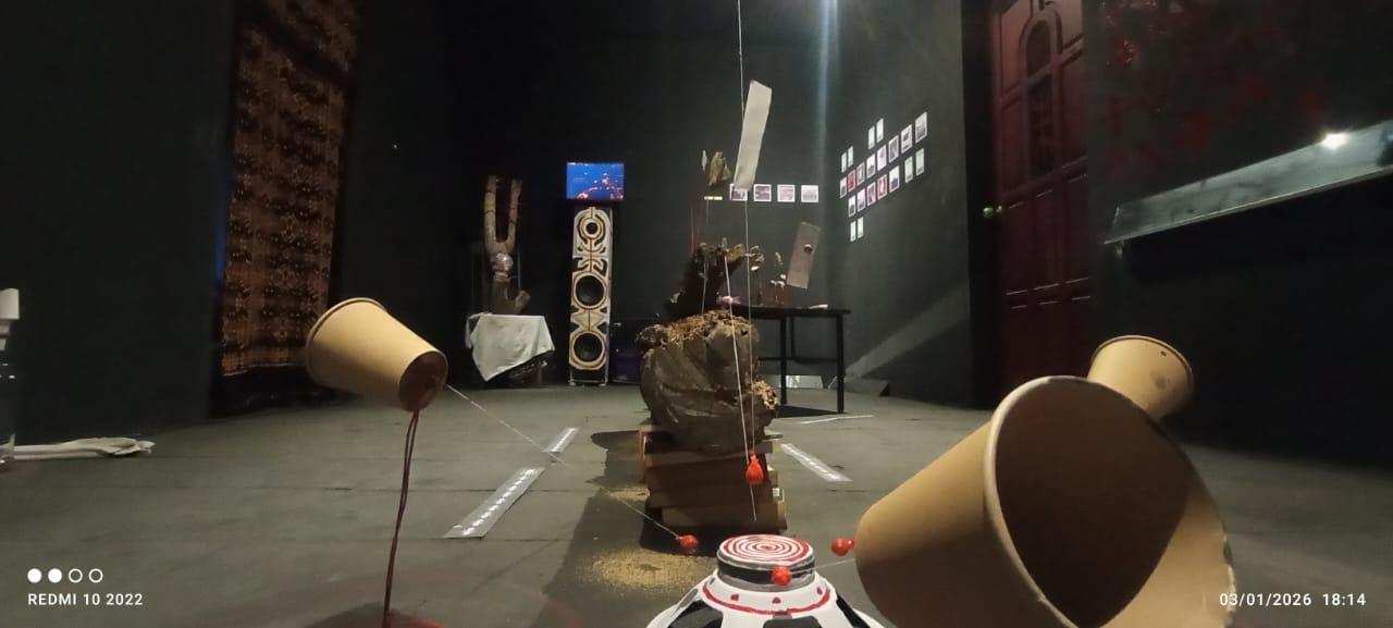 Suasana ruang pamer SISA di Rumah Tiara Coffee, Palu. Instalasi heterogen berupa benda-benda sisa, tali, tanah, dan wadah kosong disusun di ruang gelap, menciptakan lanskap simbolik tentang hubungan manusia, lingkungan, dan ruang hidup yang terus mengalami pergeseran.